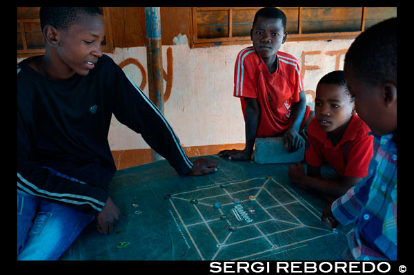 Unos niños juegan con chapas en un poblado cercano al campamento Khwai River Lodge de Orient Express en Botswana, en el interior de la Reserva Salvaje de Caza Moremi. Botswana. El patrimonio artístico más importante de Botsuana descansa en el legado de los bosquimanos, una tribu milenaria que supo plasmar, en las paredes de cuevas y rocas, su profunda espiritualidad. El arte rupestre refleja la visión que el pueblo bosquimano tenía del mundo. La belleza y sensibilidad de sus pinturas expresa el respeto del cazador por la presa, a la que según sus creencias volverá a encontrar después de su muerte.  Originaria de otra tribu, la cestería es también una tradición que se remonta a siglos pasados, cuando todavía cada recipiente tenía un uso concreto y en su elaboración se mezclaban el sentido práctico y mágico de sus gentes. Diseños de nombres tan sugerentes como “Las primeras lluvias”, “El camino del búfalo” o “Las lágrimas de la jirafa” simbolizan en sus diseños la importancia del ganado y del agua en un mundo árido donde los bienes son escasos y merecen ser celebrados.dos.  Cuando los europeos introdujeron una nueva estética, los artistas locales la interpretaron bajo los cánones de su cultura, dando lugar a una simbiosis de estilos que terminaría por tener su propia identidad. Los bordados de colchas, alfombras y manteles combinan temas africanos con diseños europeos. Se podría decir que actualmente Botsuana tiene un arte único.  El tallado de la madera, que continúa siendo una de las formas de expresión artística más comunes, participa también de la doble herencia africana y europea. No ocurre lo mismo con la cerámica autóctona del país, que permanece fiel a sus orígenes. FIESTAS En Botsuana se considera que un día no es suficiente para celebrar un acontecimiento señalado, así que se han convertido en especialistas en 'el día siguiente'. Oficialmente los días festivos son:  - 1 de enero. Año Nuevo.  - 2 de Enero: 'el día siguiente' (de Año Nuevo).  - Semana Santa: 4 días. Celebran el Viernes Santo, Sábado, Domingo de  Resurrección y 'el día siguiente' (lunes).  - Día de la Ascensión: 40 días después del Domingo de Resurrección.  - 19 de Julio: Día del Presidente.  - 20 de Julio: 'el día siguiente' (del Presidente).  - 30 de Septiembre: Fiesta Nacional.  - 1 de Octubre: 'el día siguiente' (de la Fiesta Nacional).  - 25, 26, y 27 de Diciembre: Navidades. 