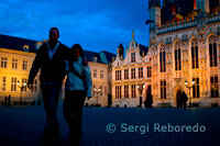 Bruges: L'Ajuntament i la Plaça de Burg. Bruges és una ciutat amb dues places. La més gran és el mercat, al centre comercial de Bruges medieval. La segona plaça es diu "Burg". Aquí estava, i segueix estant, el cor de la Bruges administrativa. Va ser aquí que el comte Balduí I tenia un castell fortificat i construït per protegir la zona contra els normands i víkings. El castell ha desaparegut fa molt de temps, així com el principal edifici religiós de Bruges, l'església de Sant Donatius, que s'ha situat en el costat oposat de la casa consistorial. On estava l'església hi ha ara un petit mur, i una reconstrucció parcial de les parets del cor de l'església. Es va construir aquí després de les fundacions de Sant Donatius el 1955. L'església va ser construïda al voltant de l'any 900. La part central era octogonal, igual que la catedral de Carlemany a la ciutat alemanya d'Aachen de la qual es va inspirar. El lloc d'oració data de l'any 900 i va ser substituït al segle 12 per una església d'estil romànic. Aquesta versió de l'església de Sant Donatius va ser destruïda en 1799 durant l'ocupació francesa dels Països Baixos del Sud. Alguns dels tresors artístics es van anar a altres esglésies (Catedral de Sant Salvador a Bruges). Diversos personatges famosos estan enterrats a San Donatius: la princesa Gunhilde (1087), el pintor flamenc Jan van Eyck (1441) i el filòsof espanyol Juan Luis Vives (1540).  