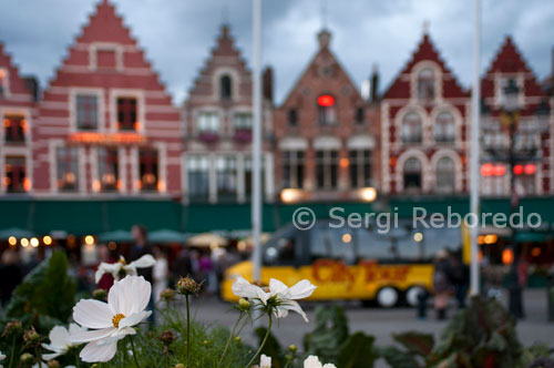 Bruges. The Markt Square and the Burg both located in the center of the Old Town are great places to start your tour. The Markt is the main town square in Bruges. This colorful area is surrounded by shops and restaurants. The Grote Markt, or Market Square in Bruges. This square was used as a marketplace since 958, and a weekly market was held here from 985 to August 1983--almost a thousand years! Today the large square is ringed by banks (with ATMs), a post office, and many guild houses converted into outdoor restaurants. The Markt is filled with pedestrians and bicyclists, and is a good place to start or end a walking tour of the city. The Belfry (bell tower) stands guard at the south end of Market Square in Brugge.