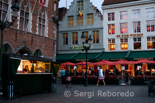 De Vier Winden (De Sneeuwberg) Restaurant. A fine setting accompanied with a delicious dinning experience, at good prices. The Restaurant is located directly on the Market Street and catches one eye immediately due to the rather surprising display of small thin screened televisions perching through the front windows. The Restaurant is split in to two sections, including a second stage. The orange room, as I call it, has a large screen TV hanging, which was showing at that time the latest mode from around the world. But I am certain that changes during popular Sport Events. The more relaxed atmosphere is in the adjoining room, (where there is no TV), presenting itself in a romantic light with fire place, decorated in a classical style, deep reds, wooden beams and candle light. The Staff is very attentive and friendly; willing to answer any questions you may have concerning Bruges itself (we tested them). We choose to eat a pot of mussels with a white wine brew accompanied with one of their specialty white wines from the region. As we would say in Swiss "Lecker", a simple form of saying "delicious".