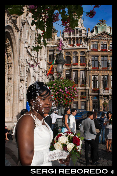 Los sábados por la mañana se celebran bodas en el Hôtel de Ville (ayuntamiento). El edificio del ayuntamiento, que ocupa la fachada suroeste, es el único edificio medieval que queda hoy en día en pie y fue construído entre 1402 y 1455 probablemente por Jean Bornoy. Su torre, asimétrica con respecto al edificio, de 96 metros de altura, es de estilo gótico y fue diseñada por Jean van Ruysbroeck en 1449. Una leyenda urbana cuenta que el arquitecto, al comprobar el supuesto error de que la torre no quedara ubicada en el centro, se subió a ésta y se arrojó al vacío, aunque en verdad ambas partes no fueron construidas al mismo tiempo. Encima de la torre se encuentra una alta estatua de bronce de 5 metros del arcángel Miguel, patrón de Bruselas, matando a un dragón o demonio. La parte izquierda del ayuntamiento consta de doce arcos, incluído el campanario, que representan la alquimia húmeda en doce etapas. En cambio, el lado derecho cuenta únicamente con siete arcos, contando el campanario, que simbolizan la nueva alquimia seca, en siete etapas. La fachada está decorada con numerosas estatuas que representan los nobles. BODA EN EL AYUNTAMIENTO DE BRUSELAS. BODAS BELGAS.