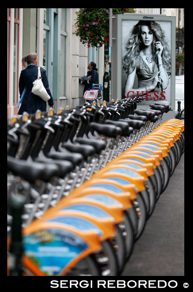 Lloguer de bicicletes municipals al centre de Brussel · les. Cada vegada són més les àrees reservades a l'asfalt de Brussel · les a les bicicletes, encara que la majoria dels passejos amb bicicleta sol realitzar per zones verdes com els voltants del Parc Laeken. Els habitants de Bruges i Gant utilitzen majoritàriament la bicicleta com a mitjà habitual de transport. Així doncs, a primera hora del matí, és possible veure a moltíssims pares portant els seus fills a l'escola amb bici, per després continuar ells sols fins al treball, fins i tot en dies de pluja. La majoria de carrers tenen un carril bici i semàfors especials. Les empreses que es dediquen al lloguer d'bicicletes estan disseminades per tota la ciutat i no costa gaire trobar-les. A Brussel · les, l'empresa Cyclocity, que ha estat desarroyada per JCDecaux i es troba en nombroses ciutats, té disseminades 250 bicicletes en 23 punts diferents de la ciutat, separats entre si a més de 400 metres. La primera mitja hora costa 0,50 euros i després es va incrementant en fraccions de 0,50 euros l'hora. En Bruges i Gant les tarifes comencen a partir dels 5-6 euros per mig dia i 9-10 euros diaris. En Bruges es poden llogar a la mateixa estació del tren: Stationsplein Telf 05 030 2329, igual que a Gant: Koningin Maria-Hendrikaplein Telf 09.241 2224. Algunes empreses no es limiten simplement al lloguer de la bici i ofereixen tours per la ciutat per descurbrirla a cop de pedal. Un dels problemes que sol succeir a l'hora de llogar la bicicleta és que en moltes ocasions se sol · licita el passaport com a fiança, cosa a la qual hem de negar-nos de forma contundent. LLOGUER DE BICICLETES AMB L'ANUNCI DE GUESS