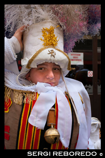 Un niño vestido con el típico traje de Binche. El festival belga de Binche con sus trajes tradicionales: príncipes orientales, marineros y arlequines. Una procesión increíble a través de las calles empedradas de la ciudad al compás de los tambores y artistas con sus máscaras de cera y sus plumas de avestruz. Toda una experiencia.  ENORME GORRO Y CASCABEL. 