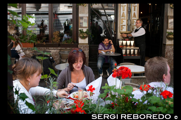 Una de las terrazas de los muchos restaurantes de Bruselas. En la cocina de los belgas, amantes de la buena mesa, no faltan grandes dosis de imaginación, y constantemente se busca ese toque que marca la diferencia también en lo referente a los platos típicos tradicionales que pertenecen a la cultura de la ciudad, como las patatas fritas con mejillones, las coles o la endibia, variedad de escarola famosa en todo el mundo. Son casi un millar los restaurantes, para todos los gustos y para todos los bolsillos, que hay repartidos por los barrios de Bruselas y por lo menos 200 están recomendados por la guía Gourmet; todos proponen recetas que, respetando la tradición, invitan al descubrimiento y a la creatividad. Entre los más innovadores destaca Le Pain Quotidien, a mitad de camino entre la panadería tradicional y el local de nueva concepción en el que se puede desayunar, almorzar y disfrutar, hasta bien entrada la tarde, hasta de un chocolate caliente. COMIENDO EN LA TERRAZA DE UN RESTAURANTE DE BRUSELAS.