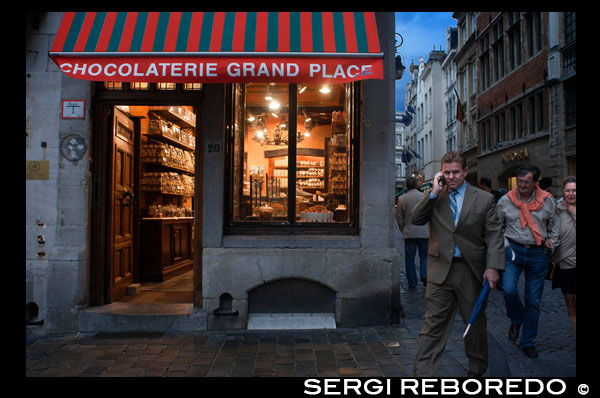 Xocolateria Grand Place, a la mateixa plaça Grand Place. La xocolata és a Bèlgica un senyal d'identitat. Les primeres fàbriques i tallers van aparèixer poc temps després que els espanyols portessin llavors de cacau des del Nou Món. En aquell temps, la xocolata era una beguda amarga només accessible a les classes més benestants. Amb el temps, els belgues van ser desenvolupant diverses formes i sabors fins al punt que els comerciants d'aquest país centreeuropeu utilitzaven la xocolata per complimentar els seus clients durant les negociacions comercials. Els belgues són els inventors del praliné que a Bèlgica es consumeix amb ametlles garapinyades. A la capital són moltes les botigues que ofereixen el producte nacional per excel · lència. A Bèlgica els bombons es comercialitzen en diversos formats i en caixes sempre presentades d'una manera molt elegant i delicada doncs la xocolata es considera al país una obra d'artesania. En Bruges es pot visitar el Museu de la Xocolata, un dels més importants del món en la seva especialitat. En les prestigioses galeries St Huberts existeixen nombroses botigues de xocolata en qualsevol dels seus tres espais: les galeries del Rei, de la Reina o del príncep però també hi ha grans botigues al llarg de la ciutat i prop de la Grand Place, al centre neuràlgic de Brussel · les. Per als amants de la xocolata dir que la xocolata belga és negre, no porta llet i el seu sabor és ple i harmoniós. Es pot adquirir de moltes formes, les més comuns en forma de bombó, pastilla o figuretes. Punt ia part és la xocolateria Pierre Marcolini, la millor mostra del bon fer belga en l'art de la rebosteria internacional. Un plaer per al paladar, per als amants a la recerca de la perfecció en el gust i l'estètica. En Marcolini són moderns i disposen xocolates, hi ha una gran varietat de galetes, sorbets o gelats. La característica principal d'Marcolini és que treballa amb un cacau seleccionat personalment pels seus especialistes buscant més el maridatge amb els millors ingredients. Les seves xocolates estrelles són la Tòfona amb xampany, el Trianon Fondant o el Envol, que ha rebut en diverses ocasions els millors guardons internacionals. No s'han d'oblidar també els Macaroons (coneguts com mostachones) que a Bèlgica són una tradició però en Marcolini es converteixen en art. Xocolateria GRAND PLACE AL CAPVESPRE