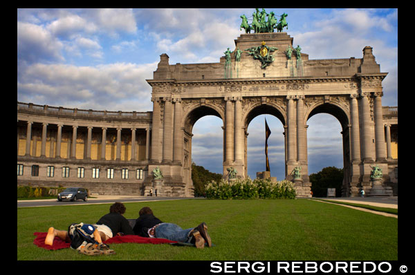 L'Arc de Triomf de la ciutat de Brussel · les està situat el Parc del Cinquantenari, l'espai verd més gran de la ciutat i un dels llocs preferits per prendre un descans ja sigui després de la feina o per als turistes. L'Arc de Triomf va ser construir, principal i inicialment com a porta d'entrada a la ciutat per les persones que arribessin per la zona est a través de l'Avinguda Tervueren. AMB UN PORTÀTIL COSTAT DEL ARC DE TRIOMF