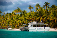 Aitutaki . Isla Cook. Polinesia . El sur del Océano Pacífico. Varios barcos turísticos amarrados en la playa en un pie . One Foot Island de Aitutaki ( Tapuaetai ) ganó el premio World Travel Award anual 15a de la mejor playa de Australasia. Las industrias de viaje equivalentes a los Oscar . Al pasar el día en la Isla de pie , es fácil ver why.This hermoso islote ofrece a los visitantes a Aitutaki algunas de las mejores vistas de la magnífica laguna de Aitutaki . La mayoría de los cruceros de un día se detienen aquí para los visitantes a disfrutar de un baño , hacer snorkel y picnic. En la marea baja se puede caminar a través del banco de arena a las islas cercanas . Sólo hay un par de casas en la isla de los pies . Uno de ellos es la oficina de correos / pasaporte más relajado que nunca se encontrará . Mientras que usted no necesita su pasaporte en pisar la Isla de pie , asegúrese de llevar a lo largo de conseguirlo estampada como un recuerdo único de su viaje al paraíso. Lo mejor de Aitutaki es , con una duda, su laguna prístina. Los taxis acuáticos son de fácil acceso y se puede despegar de su propia isla privada para disfrutar de un día íntimo de buceo inolvidable, tomar el sol o hacer un picnic romántico - lo que sea! También puede obtener su pasaporte sellado en " One Foot Island " - la atracción más popular en las Islas Cook. Uno de los aspectos más interesantes de sus viajes a las Islas Cook serán sus encuentros con la cultura y las tradiciones de nuestro pueblo. Los lugareños le dan la bienvenida con una cálida sonrisa que están seguros de que su estancia en Tamanu Beach Resort una experiencia verdaderamente inolvidable isla del Pacífico