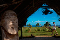 Aitutaki. Cook Island. Polynesia. South Pacific Ocean. Landscape and wood carving of Tangaroa God in Aitutaki Punani Culture Tours. Woodcarving is a common art form in the Cook Islands. The proximity of islands in the southern group helped produce a homogeneous style of carving but which had special developments in each island. Rarotonga is known for its fisherman's gods and staff-gods, Atiu for its wooden seats, Mitiaro, Mauke and Atiu for mace and slab gods and Mangaia for its ceremonial adzes. Most of the original wood carvings were either spirited away by early European collectors or were burned in large numbers by missionary zealots. Today, carving is no longer the major art form with the same spiritual and cultural emphasis given to it by the Maori in New Zealand. However, there are continual efforts to interest young people in their heritage and some good work is being turned out under the guidance of older carvers. Atiu, in particular, has a strong tradition of crafts both in carving and local fibre arts such as tapa. Mangaia is the source of many fine adzes carved in a distinctive, idiosyncratic style with the so-called double-k design. Mangaia also produces food pounders carved from the heavy calcite found in its extensive limestone caves. The outer islands produce traditional weaving of mats, basketware and hats. Particularly fine examples of rito hats are worn by women to church. 