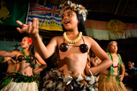 Isla Atiu. Isla Cook. Polinesia. El sur del Océano Pacífico. Los niños vestidos con danzas tradicionales de la Polinesia e interpretan danzas polinesias organizados en la isla de Hotel Villas Atiu Atiu. Las Islas Cook se encuentran al noreste de Nueva Zelanda en el Océano Pacífico Sur. Las Islas Cook están relacionadas con los maoríes de Nueva Zelanda y los habitantes de la Polinesia Francesa (comúnmente conocido como Tahiti). Islas Cook tradiciones de la danza se mantienen vivas a través de festivales, celebraciones y actuaciones para los turistas. Las Islas Cook que viven en el extranjero en los Estados Unidos, Australia y Nueva Zelanda realizan sus danzas como forma de preservación cultural. Danzas de las Islas Cook tienen mucho en común con otras formas de danza polinesia. Estilos de baile más conocido como el hula de Hawaii y el tamure de Tahití comparten la mitología y de la danza temas similares. Espectáculos de danza de las Islas Cook a menudo incluyen el canto y el canto de las danzas, que cuentan historias o sirven como comunión espiritual con los dioses polinesios. Coreografía de las mujeres: Los hombres y las mujeres bailan juntos en performances, aunque en grupos separados. Los movimientos de mujeres cuentan con de lado a lado los movimientos de las caderas. Estos movimientos son controlados por las rodillas. Las caderas deben ser enérgico, con grandes movimientos pronunciados, pero la parte superior del cuerpo deben mantenerse grácil, con los hombros restante todavía. Algunos movimientos en los brazos y las manos puede acompañar al baile, pero debe ser controlada cuidadosamente. Coreografía de los hombres: Si bien la silueta de la mujer es vertical con movimientos centrados en las caderas, los hombres bailan cerca del suelo, con movimientos más fuertes en una rodilla doblada distintiva pose.