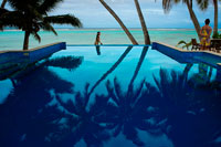 Isla de Rarotonga. Isla Cook. Polinesia. El sur del Océano Pacífico. Piscina del hotel de lujo Little Polynesian Resort en Rarotonga. El Little Polynesian es un complejo turístico en el lado sur de Rarotonga. Se compone en su mayoría de bungalows junto a la playa y un par de bungalows de jardín más pequeñas. Mientras que algunos de los otros complejos situados en la cercana Muri tienen un mejor acceso a la laguna y las islas pequeñas, la ubicación de la playa de la Little Polynesian es bastante y conveniente para la natación y otras trombas marinas. Little Polynesian Resort se encuentra en el borde de refugio marino `s Rarotonga, Laguna Titikaveka cuyas playas de arena blanca y aguas azules cristalinas son lo último magnífico lugar de vacaciones tropical. Para el alojamiento de Islas Cook de lujo que inspira el romance y la intimidad como ningún otro, Little Polynesian Resort es un destino de visita obligada. Este hotel boutique de la isla es perfecto para su escapada romántica o luna de miel. El servicio excepcional y personalizado le asegura sentir como los únicos huéspedes en el complejo. La relajación está asegurada, ya que dan a las aguas turquesas tropicales y está rodeado de exuberantes jardines tropicales. Con un restaurante y bar en el hotel, buceo y kayak equipo disponible y la impresionante belleza de los invitados del medio natural tendrá todas sus necesidades de cuidado. El personal de Little Polynesian Resort también estará encantado de ayudarle a reservar excursiones por la zona y visitas turísticas para ayudar a los huéspedes a salir a explorar la isla, si así lo desean. Little Polynesian Resort se compone de 10 sobre la playa de Ares y 4 Jardín Ares.