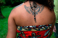 Isla de Rarotonga. Isla Cook. Polinesia . El sur del Océano Pacífico. Una mujer mostrando su espalda en un tatuaje típico polinesio o maorí . Los símbolos del tatuaje polinesio de cabezas de la lanza se pueden encontrar en casi todos los diseños de tatuaje polinesio. Está diseñado para expresar el valor y la lucha . También se utiliza para representar guerrero, artículos puntiagudos , y picadura de animales y los rayos . Cabezas de lanza se suelen utilizar en combinación con otros símbolos para expresar ciertos significados . Por ejemplo , una línea de puntas de lanza y una línea de enatas boca abajo a lo largo de su lado puede expresar el significado de derrotar enemigos . T? moko es el órgano permanente y el rostro marcado por M ? ori, el pueblo indígena de Nueva Zelanda. Tradicionalmente es distinto del tatuaje y tatau en que la piel fue tallada por uhi ( cinceles ) en lugar de punción . Esto dejó la piel con ranuras , en lugar de una superficie lisa . Artes del tatuaje son comunes en el país de origen polinesio oriental de M ? Ori, y los instrumentos tradicionales y los métodos empleados fueron similares a los utilizados en otras partes de Polinesia (ver Buck 1974:296 , citado en las referencias más abajo). En la cultura M pre-europeo maorí , muchos, si no la mayoría de personas de alto rango recibieron moko , y los que se fueron sin ellos eran vistos como personas de condición social más baja . Moko Recibir constituyó un hito importante entre la niñez y la edad adulta , y fue acompañado por muchos ritos y rituales.