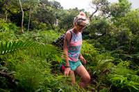 Rarotonga Island. Cook Island. Polynesia. South Pacific Ocean. A tourist crosses the island of Rarotonga in the Pa’s trekking. The most popular of these is the cross-island mountain trekking, which takes approximately four hours. This includes a stop at 'The Needle', a unique rock formation high above Rarotonga. The Takitumu Conservation Area offers gentle nature walks through lush forest and along mountain streams, where you will find a number of rare and endangered species of plants and birds. Whether you call it trekking , tramping or hiking, in Rarotonga you will get the chance to see many native bird species as well as exotic butterflies and plenty of endemic plants and ferns. Tramping or hiking is an easy one day activity, and it is possible to do it alone. However if you are wanting to attempt the main cross islands walk there are no signposts, and the trail itself is quite difficult to find and follow in places, not to mention quite treacherous and hard going in the wet season. It is advised to engage Pa a local tramping guide, as many people have been injured or worse, attempting this hike alone. Pa Mountain Trekking is one of the best organized hikes on Rarotonga. The hike is around 4 hours long and is a wonderful educational experience for the entire family to enjoy. Not only do you get to learn about the local flora and fauna, but Pa is well known for telling many ancient myths and legends associated with the island. 