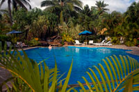 Rarotonga Island. Cook Island. Polynesia. South Pacific Ocean. Swimming pool of the Crown Beach Resort & Spa Hotel. The Resort is a full service yet intimate luxury boutique resort with 36 individual villas, located amongst 4.5 acres of tropical gardens. Situated at Aroa beach on Raratonga, the Crown Beach Resort has a luxury spa for those in need of relaxation and some pampering. For the active guest there is a gym, and activities such as the cultural tour, an off-road tour and whale spotting excursions. Nestled amongst acres of tropical gardens and bordered by the white sand beaches and a crystal blue lagoon, lies the 36 Crown Beach villas, all set with the utmost care and attention to detail in each room.  The utmost care has gone into the design and decor of these luxurious rooms creating an absolute haven for you and your loved one, choose between your own private swimming pool or Jacuzzi for intimate moments in complete privacy. The resort offers an onsite spa and beauty clinic to enhance your relaxing stay, be pampered by the wonderful treatments and talented staff. Enjoy an evening of culinary delights at any of the resorts three onsite dining venues, Windjammer Restaurant offers intimate, fine dining, Tan Tapas Lounge presents an exotic atmosphere with and serving Spanish Tapas.  