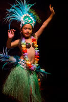 Rarotonga Island. Cook Island. Polynesia. South Pacific Ocean. Highland Paradise Cultural Village. A girl dressed in traditional cook island costumes dance during the Highland Paradise Cultural Village show. This 600 year old village site was home to the famous Tinomana Tribe but was abandoned in the early 1800s with the introduction of Christianity. The Pirangi family, descendants of the original High Chief Tinomana, has ensured the survival of this 205 acre mountain refuge by re-discovering and re-opening it to Cook Islanders and visitors alike. Now once again, you can experience the strong and meaningful spiritual bonds associated with the land, the maraes and the people (past and present) of this unique and colourful tribe. During your hours at Highland Paradise, you will discover ancient, significant places and examples of worship, chiefly council, warfare, sacrifice, tribal justice, home making, agriculture, medicines, fishing, education and canoe voyaging. We have reproduced buildings, re-installed artefacts and uncovered sites of great importance to our people. The 25 developed acres are but a tiny part of this site, but within this area you will relive the village as it was for more than 500 years. Native, introduced and medical plants are abundant and the gardens a delight to behold.