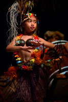 Rarotonga Island. Cook Island. Polynesia. South Pacific Ocean. Highland Paradise Cultural Village. A girl performs traditional dances of the Cook Island during the Highland Paradise Cultural Village show. Our Wednesday and Friday sunset cultural nights include hosted roundtrip transport, guides, village experience visit, tapu lifting, warrior welcome, a cocktail, a traditional Umu (underground oven) feast and a spectacular stage show telling the story of our ancient heritage through singing, dancing and drumming. Our dancers, musicians, chefs, barmen and guides are all descendants of Ariki (High Chief) Tinomana and are proud to be part of the extended family which brings this mountain village back to life – for you! Puaikura villagers are involved in all aspects of the Highland Paradise experience, as guides, dancers, drummers, warriors, weavers, carvers, cooks, medicinal experts and many more. Most are understudied by village children - a legacy for the future. Guests are transported by coach from their accommodation in the late afternoon to Highland Paradise where an evening of utterly unique and truly authentic cultural entertainment and feasting awaits!