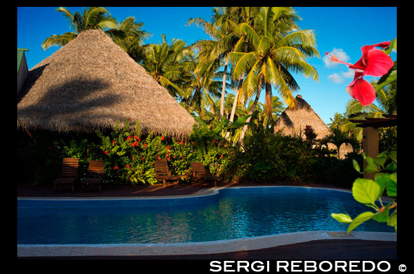 Aitutaki. Cook Island. Polynesia. South Pacific Ocean. Swimming pool of Aitutaki Lagoon Resort & Spa Hotel. Right beside the Activities Hut is the waterfalls swimming pool. Which is handy, as that’s also right beside Aroa Beach. And because The Rarotongan is luckily located right on the sunshine southwest coast, this means there’s sunshine all day on the freshwater pool, the beach, and the lagoon – right up until sunset that is (often a glorious, blazing island sunset). There’s plenty of comfortable pool loungers to enjoy, so grab your complimentary pool / beach towel from the Activities Hut and make yourself comfortable for another day in Paradise. After you’ve soaked up some rays, take a cool dip in the pool. Someone’s gotta do it. The sublime Aitutaki Lagoon Resort & Spa rests effortlessly on its own secluded, private island of Motu Akitua - the only private island resort in the Cook Islands. Just a 2 minute ride from the main island of Aitutaki by small private ferry, the isle of Motu Akitua is encircled by broad, expansive beaches the colour of champagne. From here, you as our guest are able to enjoy the only resort facing directly onto the world's most beautiful lagoon, and from here, you can drink in spell-binding views of one of the Wonders of the World to your heart's deep content. Nothing will prepare you for the intensity, the vibrancy, the omniscience, of the lagoon's blue expanse. So intense, so expansive, it is not just a colour you see, it is a blue you feel with every fibre of your being. This is the reason you have journeyed all the way across the oceans, to see, to feel, to truly experience the world's most beautiful lagoon. Staying at The Aitutaki Lagoon Resort & Spa, you will have the opportunity not just to see Aitutaki Lagoon as a day tourist might, but to really experience this true Wonder of the World in all its moods. As day breaks, take your beloved by the hand and stroll in the morning stillness. Lithe, long-legged herons will be out, dipping elegantly into the lagoon's placid glaze. Crabs will be emerging to warm themselves in the day's new sun. And sleeping fishes will be awaking to the day's new thrill. Over a breakfast of succulent, sweet tropical fruits and fresh-baked pastries, gaze out as the sun fires up this mystical lagoon into a vibrant, super-real intensity of blue such as you've never seen before, nor will again. As the day unfolds, watch as the sun lights up the tiny motu floating in the horizon into verdant green, green dots bob, bob, bobbing on a sea of blue. This is indeed a heady combination - the clear South Pacific sun, the swathes of fine white sands, the stillness of your own private island enclave, the big blue sky above, and the endless, everpresent blueness of the lagoon below. A colour so all-embracing you will find yourself willingly succumbing to its power, a power to transfix you into a new state of stillness. As the day draws to a close, gaze out as the lagoon is transformed into a blaze of oranges, pinks, yellows and reds playing on its surface. The big blue sky will transform into a dark, velvety canopy sparkling with a million, trillion diamonds. And as the big, fat yellow moon rises, you will recall that the channel which divides your private island sanctuary from the main island is named O'otu Channel - Full Moon Channel - in remembrance of that night so very long ago when the chiefly Ru - having voyaged across the ocean in his grand Polynesian vaka with his entourage of wives, maidens, brothers and warriors - was the first man to gaze upon Aitutaki, by the light of the full moon.