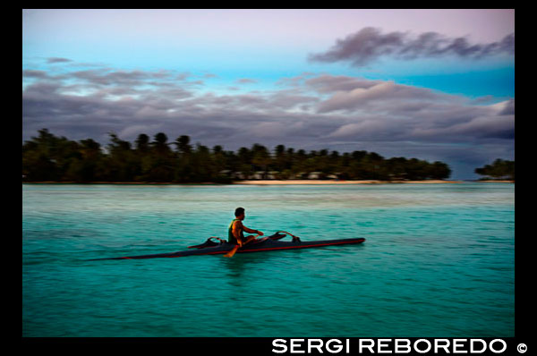 Aitutaki. Cook Island. Polynesia. South Pacific Ocean. A tourist practiced rowing next to the beachside Aitutaki Lagoon Resort & Spa Hotel. Aitutaki Lagoon Resort’s staff are here to help with all your questions and activity needs. From our reception desk hire motor scooters, bicycles or a car to tour the island or book an organised tour – scuba diving, deep sea fishing, lagoon cruises and much more. Two dedicated activities staff are available to help you enjoy our complimentary canoes, kayaks, windsurfers, snorkelling equipment, beach volleyball, reef walks and more. The famous Aitutaki Lagoon Cruise departs from the resort entrance. Simply book your ticket at reception and prepare for an amazing day of turquoise water, deserted islands and fresh fish BBQ.  Restaurants & Entertainment: Our two restaurants provide excellent dining and entertainment. Indulge in a cocktail before dinner at Are Kai Kai Restaurant or try lunch at beach side Ru's Bar & Grill. Every night brings superb Polynesian entertainment including a traditional dance and drum show right on the beach. Join us under the stars.. Aitutaki Lagoon Resort & Spa is the Cook Islands’ only private island resort, and the only resort on the world’s most beautiful lagoon, fabled Aitutaki Lagoon. This intimate resort offers the Cook Islands’ only Overwater Bungalows and now, new Premium Beachfront Bungalows. At this idyllic romantic retreat enjoy breathtaking lagoon views, champagne sand beaches, inviting warm waters and dining under the tropical moon and southern stars. Here at Aitutaki Lagoon Resort & Spa feel free to laze in a beach hammock, slip into the luminous lagoon, ease into a soothing massage at SpaPolynesia, then sit back and relax with a sunset cocktail at the enchanting Flying Boat Beach Bar & Grill. Aitutaki Lagoon Resort & Spa is especially ideal for wedding and honeymoon couples offering the beautiful Royal Honeymoon Pool Villa and dedicated wedding venue, Oneroa Beach Chapel. For those wanting to enjoy one of the world’s best lagoon playgrounds the Watersports Centre offers complimentary stand up paddle boards, windsurfing, kayaking, outrigger canoes. The ultimate romantic South Seas island retreat.