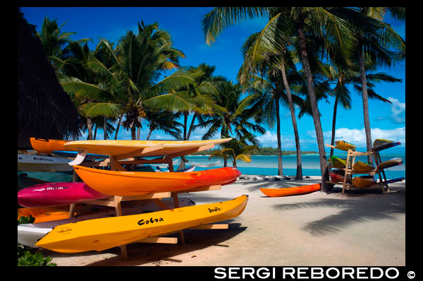 Aitutaki. Cook Island. Polynesia. South Pacific Ocean. Some kayaks await tourists on the beach in Aitutaki Lagoon Resort & Spa Hotel.  Go Kayaking - Kayaking is an easy, fun, and relaxed way to explore the lagoon around Rarotonga island. The best place for kayaking on Rarotonga is around Muri Beach and the southeast coast near four uninhabited islands. The Cook Islands consist of 15 islands scattered over an area of about 2 million square kilometers in the Pacific Ocean. The islands are little snippets of paradise that invite you to come and get away from it all, to soak in the sun and thousands of years of Polynesian history and culture. Rarotonga is the largest and most visited island. This place is completely surrounded by a reef which means beautiful white beaches and tropical turquoise waters, while imposing mountain peaks, interspersed with dense rain forest, make for some fantastic scenery on the island.   Muri Beach - This popular beach is situated on the southeast corner of Rarotonga and is protected by a lagoon. A kayak or canoe can be hired here for about $13 USD for a day. There is good snorkeling too. Aitutaki Day Cruise - The southern island of Aitutaki boasts the world’s largest coral lagoons, inhabited by huge clams and multicolored tropical fish. Scuba Diving - The dive sites on the Cook Islands are considered perfect for beginner divers because the sites are close to the shore and the currents aren’t too strong. Te Vara Nui Village - Te Vara Nui Village is the cultural center where you can learn about the history of the native population. Ura Po is a popular thing to do. It is a dining and island night show on floating and fixed stages set in botanical gardens surrounded by waterfalls. Hiking - There are several excellent hikes around the main island of Rarotonga.  The most popular trails include Papua Waterfall, Avana Valley and Raemaru Lookout. Each take around 2 hours to complete. Pa’s mountain treks offer quite strenuous three-hour hikes across Rarotonga, passing Te Rua Manga at 413 meters with great views toward the coast. Tinomana Palace - The palace is a two-story formation of coral and lime. It is located in Arorangi village and was constructed by the British. The name means ‘The Peace Brought by Christianity’. Traditional Dance Shows - These dances are based on traditional island stories passed down through the generations. There are many places here where you can combine a dinner and dance show. It’s a little touristy, but still festive and entertaining. Fishing - The Cook Islands offer exceptional opportunities for deep sea game fishing. The currents, reefs and submarine topography foster ideal conditions for wahoo, barracuda. dolphin fish, yellowfin and skipjack tuna, sailfish, marlin and mahi mahi. Aitutaki Marine Research Center – This small research center is often working on some form of marine restoration and has green sea turtles which visitors are able to pick up. Punanga Nui Market – This market in town is filled with many locally made crafts, produce, baked goods, musicians, and people. Arai-Te-Tonga Koutu-nui-Ariki – Not far from town lay the ruins of an ancient royal court. This particular area is where tribal feasts were held. There is a 10-foot platform and large stone pillars, though most of the area is overgrown. Papua Waterfall – This waterfall is at the end of a beautiful hike and has a natural pool to swim in. Brush up on your Marine Biology – The Cook Islands Whale and Wildlife museum is a tiny place, but offers lots of interesting displays of fossils and skeletons. It’s a good option for a stormy day, or if you just need to get out of the sun. Snorkel the Maitai Wreck - In 1916, a boat carrying a load of Model T Fords sunk off the coast of Roratonga. The wreck is only four or five meters underwater, and clear visibility makes it great for snorkeling. 