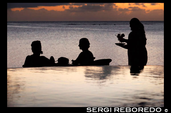 Aitutaki . Isla Cook. Polinesia . El sur del Océano Pacífico. Una camarera sirve deliciosos cócteles en la playa en el lujoso Hotel Pacific Resort Aitutaki . Pacific Resort Aitutaki es una colección íntima de 27 absolutos bungalows frente al mar , suites y villas , todas con su propio punto de vista único de la famosa Laguna de Aitutaki . Este establecimiento, Cook Islands ofrece atardeceres memorables y una configuración de isla tranquila para el más relajante de vacaciones. No hay mejor lugar para pasar su luna de miel Islas Cook. 2012 fue un año muy ocupado para PRHG jactándose numerosos reconocimientos de premios de viajes internacionales que consolidan claramente su posición como el mejor de su clase en todo el todo el Pacífico Sur y en el camino de poner las Islas Cook en el mapa en términos de excelencia en calidad, servicio , la hospitalidad y la experiencia del huésped. Premios recogieron el año pasado incluyen Premios HM para Hotelería y Alojamiento Excelencia , World Travel Awards , Premios de TripAdvisor y Nueva Zelanda Travel Industry Awards . 2013 está tratando de seguir su ejemplo. Y cuando llega el momento de comprar un recuerdo o un regalo para llevar a casa de su viaje Aitutaki, entonces usted puede encontrar tiendas en Aitutaki con pareaus pintados a mano y camisas tropicales para recordarle sus vacaciones laguna de Aitutaki . Usted incluso puede venir a través de un sujetador de coco o un ukelele mientras que las compras en Aitutaki Islas Cook, para que pueda mostrar a la gente de vuelta a casa lo que una noche la isla es como!.