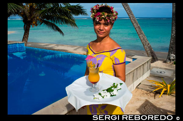 Isla de Rarotonga. Isla Cook. Polinesia . El sur del Océano Pacífico. Una camarera sirve deliciosa junto a la piscina en el lujoso Little Polynesian Resort en Rarotonga. Ubicado en el extremo sur de Rarotonga, Little Polynesian Resort es un parque infantil sofisticado para adultos. Aquí, la serenidad es cierto , el aislamiento está garantizado, y el romance está en todas partes . Este es un Resort de lujo sin pretensiones , donde las playas idílicas hacen señas . Los Ares frente a la playa ofrecen una vista ininterrumpida de la laguna azul , mientras que la vista de los jardines tropicales de las Ares paja jardín es igual de deslumbrante. Celebrando los huéspedes mayores de la edad de sólo 15 años, la clientela principal del Resort son recién casados ??y parejas . Situado en una playa virgen , las viviendas Resorts rezuman encanto de la Polinesia y el lujo. Pasan sus días vagando por las playas y bebiendo cócteles de fruta fresca en la piscina. La arquitectura tradicional complementa la belleza natural de la isla, y los bungalows están diseñados con todo el lujo moderno, desde gazebos con camas de día a las duchas al aire libre. Experimente el epítome del lujo de la Polinesia en nuestros alojamientos de playa y jardín muy bien dotadas. El romance de la arquitectura tradicional polinesia reúne las comodidades de Occidente en nuestras interpretaciones modernas de las viviendas locales , o son como son conocidos . Dictada en una paleta minimalista de maderas de marfil y locales , la sobria elegancia de nuestras habitaciones tiene el cociente el romance a un nivel superior . Acentos tradicionales como Wild Hibiscus, Mangaian ( coco) Sinnet tejiendo en vigas , así como un techo de paja con pandanus naturales se suman al ambiente de nuestra Mares del Sur paraíso. El Little Polynesian ofrece todas las comodidades que se esperan de boutique resort más exclusivo de las Islas Cook . Nuestros Ares overbeach (bungalows) prometen día sin rumbo de vistas a las aguas turquesas de la laguna y despertarse con el suave sonido de las olas, mientras que el aroma de las flores tropicales llena el aire alrededor de nuestras unidades ( jardín ) Pia Tiare . Cualquiera que elija , le garantizamos que se verá inmerso en la naturaleza en el Little Polynesian