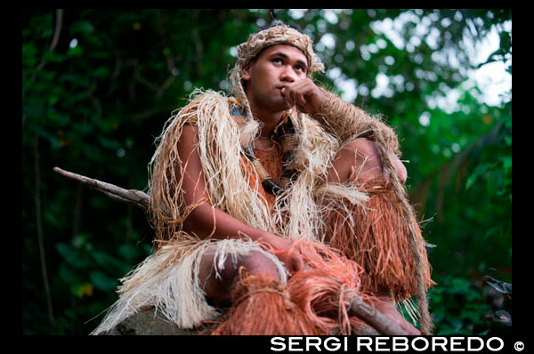 Illa de Rarotonga. Illa Cook. Polinèsia. El sud de l'Oceà Pacífic. Un home amb la roba dels maoris caçador a Highland Paradise Cultural Village mostrar. A mitjan 1980, el mort Raymond Pirangi Superior, 01:00 rangatira (sotscap) de la prominent Rarotongan Tinomana tribu, es va encarregar d'exposar per reclamar la seva herència de l'arbust dens descoratjador i vessants escarpades de Maungaroa. El seu somni i la determinació de compartir tot això amb la resta del món s'ha traduït en la resurrecció d'un dels més importants llocs d'interès històric de les Illes Cook. Situat a la part alta de les escarpades muntanyes de Rarotonga, amb vista sobre la llacuna aqua, que voregen els esculls de coral i l'oceà Pacífic, això, impressionant lloc de 205 hectàrees verges és d'un important patrimoni cultural i era un refugi espiritual i fortalesa segura per a les famílies, dels guerrers i la Tinomana principalment line per incomptables centenars d'anys. El Centre Cultural Highland Paradise ofereix una veritable experiència interactiva per als vilatans i visitants per igual. Aquí, vostè podrà reviure personalment als nostres ahirs polinèsies través autoguiada o guiada interactiva al lloc tranquil passeig passejos entre els exuberants jardins, restes del llogaret, rèpliques de ares (cases), àrees històriques de gran importància i els majestuosos arbres nadius.