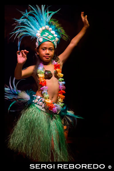 Rarotonga Island. Cook Island. Polynesia. South Pacific Ocean. Highland Paradise Cultural Village. A girl dressed in traditional cook island costumes dance during the Highland Paradise Cultural Village show. This 600 year old village site was home to the famous Tinomana Tribe but was abandoned in the early 1800s with the introduction of Christianity. The Pirangi family, descendants of the original High Chief Tinomana, has ensured the survival of this 205 acre mountain refuge by re-discovering and re-opening it to Cook Islanders and visitors alike. Now once again, you can experience the strong and meaningful spiritual bonds associated with the land, the maraes and the people (past and present) of this unique and colourful tribe. During your hours at Highland Paradise, you will discover ancient, significant places and examples of worship, chiefly council, warfare, sacrifice, tribal justice, home making, agriculture, medicines, fishing, education and canoe voyaging. We have reproduced buildings, re-installed artefacts and uncovered sites of great importance to our people. The 25 developed acres are but a tiny part of this site, but within this area you will relive the village as it was for more than 500 years. Native, introduced and medical plants are abundant and the gardens a delight to behold.