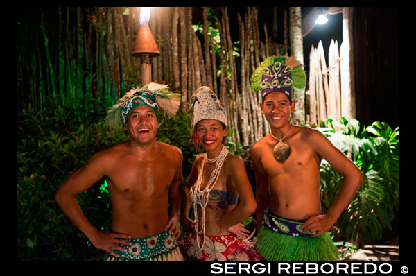 Rarotonga Island. Cook Island. Polynesia. South Pacific Ocean. Some participants in the the Highland Paradise Cultural Village show.  Dressed in traditional costumes of the Cook Island. Traditional dance is known as ura. Dancers move their bodies to express the stories of the islands, accompanied by singing and drumming. Ura began as a sacred ritual in Polynesia and has now become a popular dance form. Watch the hands as well as the hips and legs - different gestures symbolise different meanings. The dancers are telling stories of birds, flowers, the ocean and, of course, of love and loss, the sadness and joy of we humans. Distinctive to the sound of Cook Islands music is the full and resonating drumbeat. A typical Cook Islands drum team involves five or more drummers setting the tempo and directing the body and hand movements as well as the hip and leg motion. Cook Islands drums can be divided into three groups: wooden drums or slit gongs, skin or 'true' drums and specialised rhythm makers, which imitate or substitute drum rhythms. The drumming is some of the world's best. A typical drum team usually involves five or more drummers: a lead drummer (pate taki), support lead (pate takirua), a double player (tokere or pate akaoro) on wooden gongs, and two other players on skin drums (pa'u and mango). The basic one-one beat of the pa'u sets the sideways motion of the hips and the inward snapping of the knees of dancers. A second basic beat is produced from the pate, which directs the hand and body movements of dancers. The other drum instruments take on supporting roles although they do occasionally take over the control of movements.