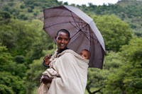 Retrato de una madre junto a su hijo a los pies de las Cataratas del Nilo Azul (río Abay).  Las cataratas del Nilo Azul, en lengua amariña Tis Abay (humo de agua), son uno de esos lugares míticos con los que una sueña cuando lee historias sobre antiguos exploradores, descubridores.. Precisamente, Pedro Páez, un alcarreño nacido en 1564 en un pueblecito de la hoy Comunidad de Madrid, fue el primer europeo "moderno" que estuvo aquí. Era un misionero jesuíta, que se convirtió en un experto de las lenguas y cultura autóctonas, y tuvo la suerte de conocer la sobre fuente del Nilo Azul, en 1613. 