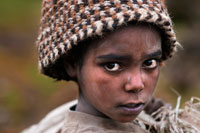 Retrato de un niño junto a las montañas de Simien. Las bellezas de los montes Simien son genuinas y universalmente admiradas, ante ellas solo resta la contemplación. Uno puede preguntarse que fuerzas y poderes sobrenaturales han creado esta maravilla.El parque nacional de las montañas Simien tiene muchas cimas por encima de los 4000 m, siendo Ras Dashen el pico más alto de Etiopía y el cuarto de Africa con 4620 m. Con al menos tres diferentes zonas botánicas, el parque es conocido por su diversa ecología, fauna y flora. Tres de los siete grandes mamíferos endémicos de Etiopía – la cabra Walia, el babuino Gelada y el zorro rojo de los Simien, se encuentran aquí.