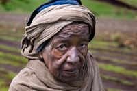 A local woman walks among the slopes of the Simien Mountains. Simien Mountains, located in northern Ethiopia 100 km from the city of Gondar, is a beautiful mountain range was declared a World Heritage Site by Unesco in 1978. It has several peaks over four thousand feet, deep valleys and a huge variety of endemic animals like Simien wolf, Walia Ibex and Gelada baboon animal well as the hyena and leopard.