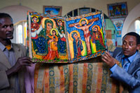 Unos sacerdotes muestran los libros sagrados de la nueva iglesia de St Mary  of Zion en Axum. Las iglesias etíopes cuentan con varias entradas: la entrada sur para mujeres y la norte para hombres; la oriente puede ser usada indistintamente. Construidas siguiendo un esquema inspirado en el Templo de Salomón, tienen tres partes: un coro, un espacio sagrado donde se reparte la eucaristía y un santuario cerrado accesible sólo a los sacerdotes. Ahí, en esa parte llamada “sagrado de lo sagrado”, cada iglesia guarda un Tabot, una réplica del Arca y de sus Tablas de la Ley, en un pequeño cofre de madera. 