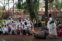 Varios niños y niñas separados hacen catequesis en el interior del recinto de la iglesia de St Mary  of Zion en Axum. el Arca de la Alianza es una reliquia venerada fervorosamente por los etíopes razón por la cual las iglesias guardan en su recinto más sagrado una réplica del Arca de la Alianza que contiene el Tabot. El Tabot que se guarda en las iglesias etíopes es una réplica (en madera o piedra) de las Tablas de la Ley cuyo original se conservaría en Santa María de Sion , en Axum. Nos encontramos en Axum, ante la fachada de la Iglesia de Nuestra Señora de Sion, lugar en el cual y según asegura la tradición se encuentra actualmente el Arca de la Alianza. En el interior del templo una única persona, un sacerdote, un elegido, un descendiente directo de los levitas, guarda celosamente el tesoro y no permite que nadie lo toque o lo vea.