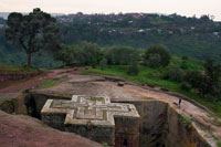 Església de Sant Jordi a Lalibela. L'església de Sant Jordi és la principal de les onze esglésies excavades a la roca de Lalibela, ciutat santa per als cristians etíops situada al nord d'Etiòpia. Aquestes esglésies són Patrimoni de la Humanitat segons la Unesco i representen la ciutat de Jerusalem (tenen el seu portal de Betlem, la seva porta al Paradís ...). Suposen el centre de pelegrinatge major d'Etiòpia i la llegenda explica que en la seva construcció van ajudar els àngels, que treballaven de nit. Si en la visita a aquest conjunt d'esglésies rupestres, deixes per al final la de Sant Jordi, no et penediràs perquè l'efecte final no pot ser més impactant. L'escena és bíblica. Els rostres, la vestidura, els resos, els càntics, el fervor, l'entorn grandiós de muntanyes pelades: un se sent projectat enmig de l'Antic Testament. Els fidels, per milers, estan escampats per tot arreu, alguns asseguts, altres de genolls, altres estirats.