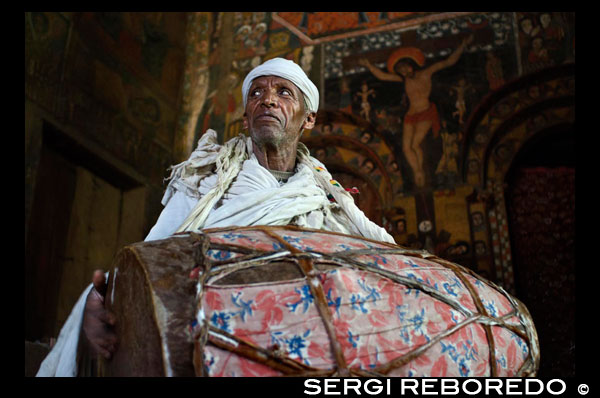 Un sacerdote hace tocar el tambor en el interior de la Iglesia Debre Birhan Selassie (también llamada de los Querubines. A las afueras de la ciudad de Gondar se encuentra la iglesia Debre Birhan Selassie muy conocida por sus pinturas murales, se encuentra en una colina sobre la ciudad, con paredes hermosamente pintadas que cuentan muchas historias religiosas. Si se mira hacia arriba se ven las ochenta cabezas aladas de querubines etíopes sonriendo, todos ellos con una expresión ligeramente diferente. Es el techo mas famoso de Etiopía. 