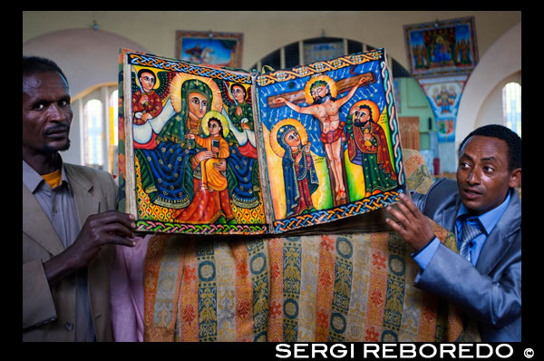 Unos sacerdotes muestran los libros sagrados de la nueva iglesia de St Mary  of Zion en Axum. Las iglesias etíopes cuentan con varias entradas: la entrada sur para mujeres y la norte para hombres; la oriente puede ser usada indistintamente. Construidas siguiendo un esquema inspirado en el Templo de Salomón, tienen tres partes: un coro, un espacio sagrado donde se reparte la eucaristía y un santuario cerrado accesible sólo a los sacerdotes. Ahí, en esa parte llamada “sagrado de lo sagrado”, cada iglesia guarda un Tabot, una réplica del Arca y de sus Tablas de la Ley, en un pequeño cofre de madera. En días religiosos importantes el Tabot sale en procesión del sacro santorum cubierto por una tela drapeada. Nadie parece preguntarse cómo, si de acuerdo a la leyenda quien mire el Arca queda ciego o incluso muere, es posible que todas las iglesias tengan una copia de ésta. Mis preguntas al respecto causaban molestia: para los etíopes lo relacionado con Arca es un dogma de fe. El Kebre Negest narra como a los 22 años Menelik regresó a Jerusalén a visitar a su padre, el Rey Salomón, quien le ofreció heredar el trono; ofrecimiento que declinó. Entre los acompañantes de Menelik se encontraba el hijo mayor de un alto sacerdote, quien hurtó el Arca tras soñar que debía llevarla consigo. Menelik enfureció al enterarse del hurto, pero luego a su vez soñó que eso era la voluntad de Dios y siguió su camino. Cuando el Rey Salomón se dio cuenta del robo pensó en enviar un ejército a perseguir a su hijo, pero él también soñó que era la voluntad de Dios y mantuvo la desaparición del Arca en secreto. La versión respecto a Makeda y Salomón, en la tradición judío ortodoxa de la falasha de Etiopía, es prácticamente idéntica a la del Kebre Negest. A pesar de ser una historia desestimada por los historiadores occidentales, los etíopes la aceptan sin dudar. Están convencidos que el Arca original fue llevada a Axum en el primer milenio antes de Cristo y que permanece ahí desde entonces.