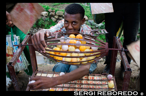 En la aldea de Gashena, no muy lejos de Lalibela se respira un ambiente de cotidianidad absoluta, tanto es así que incluso juegan al bingo en plena calle. Gashena es un pueblecito muy pequeño donde aprovecharemos para ver el mercado, el último realmente auténtico que veremos por Etiopía. Se encuentra muy cerquita de la carretera en una gran explanada. Se trata de un mercado muy pero que muy local, los productos que allí se venden son para satisfacer a las aldeas cercanas pero aquí pocos turistas paran a hacer una visita y eso se nota nada más poner el pie en el mercado. Nos reciben con miradas curiosas y sonrisas cómplices que nos hicieron sentirnos relajados desde el primer momento. Me pedían constantemente que les hiciese fotos y se ponían bien sus pañuelos y gorros para salir en ellas. Los más atrevidos intentaban practicar un poco inglés.