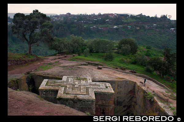 Església de Sant Jordi a Lalibela. L'església de Sant Jordi és la principal de les onze esglésies excavades a la roca de Lalibela, ciutat santa per als cristians etíops situada al nord d'Etiòpia. Aquestes esglésies són Patrimoni de la Humanitat segons la Unesco i representen la ciutat de Jerusalem (tenen el seu portal de Betlem, la seva porta al Paradís ...). Suposen el centre de pelegrinatge major d'Etiòpia i la llegenda explica que en la seva construcció van ajudar els àngels, que treballaven de nit. Si en la visita a aquest conjunt d'esglésies rupestres, deixes per al final la de Sant Jordi, no et penediràs perquè l'efecte final no pot ser més impactant. Jo la vaig veure per primera vegada al capvespre i amb pocs turistes voltant, sublim seria un adjectiu altisonant, però encertat. Bete Georgis es troba allunyada de la resta d'esglésies de Lalibela i segons t'aproximes, passa totalment desapercebuda, en no elevar-se per sobre del nivell de la terra. Quan estàs ja prop, de sobte, apareix davant els teus ulls enmig del turó. És com si un nen hagués fet una figura d'una creu amb un motlle a la sorra, amb la diferència que no es tracta d'tova sorra de platja, sinó de roca basàltica vermellosa. L'espectacle és impressionant de prop, sense descendir a l'entrada del temple, ja que es pot apreciar gran part de l'església, amb els seus murs una mica inclinats i el viu contrast del vermell de la roca amb el verd intens de la molsa que creix en els murs. Preciós i increïble l'esforç que va haver de implicar la construcció d'un edifici així en els temps del rei Lalibela (s. XIII).