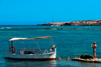 Formentera. Els Pujols beach in Formentera. Tourists taken pictures with traditional fishing boat in summer day. Llaüt. 