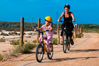 Formentera. Madre e hija están montando en una bicicleta. Lago Pudent. Formentera. Islas Baleares, España, Europa. Ruta en bicicleta.