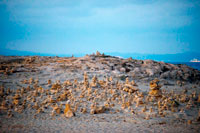 Formentera. Ses Illetes Playa, Islas Baleares, Formentera, España. Retroiluminación de la puesta del sol con piedras de diferentes formas. "El Diluvio" ("La Riada"), un espacio único construido con piedras por parte de la Johannes Schultz alemán.