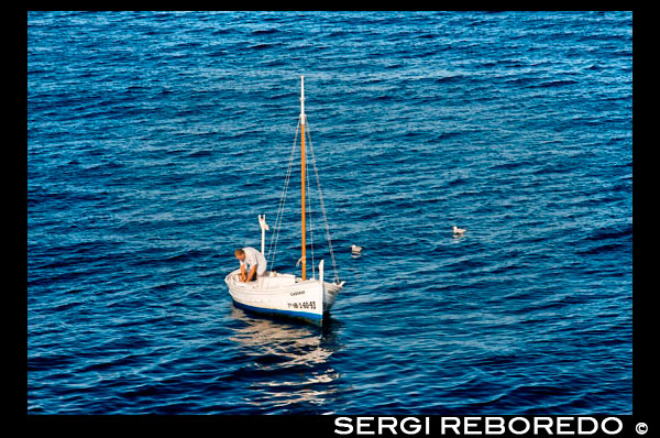 Fisher con barco de pesca tradicional en el día de verano. Llaüt. Afortunadamente, ya pesar de las condiciones climáticas pésimas ese día, la recepción de señal portátil y la patrona de los pescadores catalanes respondieron a la oración con un mensaje para quitar el timón del barco que se hunde. Nuestro navegante incondicional, por ahora hasta las ciruelas en congelación salobre, apenas logró completar esta tarea antes de su buque afectada desapareció bajo la superficie. Milagrosamente el aullido del viento dio vuelta y se aferra al timón de madera para la flotabilidad Josep voló de nuevo hacia el puerto donde ansiosas manos lo arrastraron con seguridad en tierra. Un pobre pescador que no tienen seguro, Josep podía darse el lujo el costo de la construcción de un nuevo barco con el que continuar su sustento. En el lado positivo, sin embargo, por lo menos él no tuvo que comprar un nuevo timón.