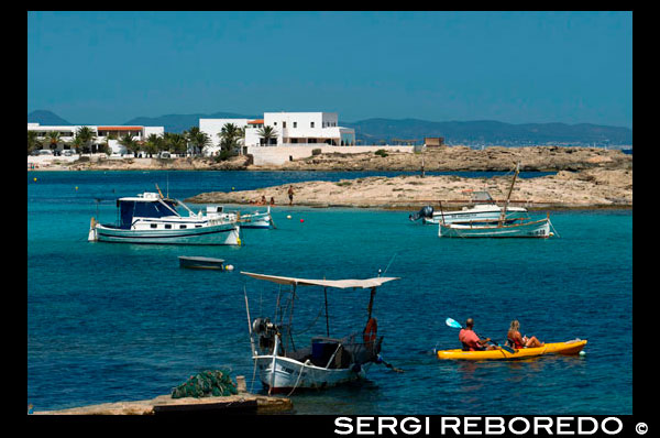 Playa Els Pujols en Formentera con el barco de pesca tradicional y kayaks en día de verano. Barcos Llaüt. Si usted está planeando ir a Formentera, recomiendo encarecidamente su estancia en Es Pujols. A menos que la mente una fuerte presencia italiana. Lo que no es mi caso. Es Pujols es la ciudad de mayor actividad en Formentera y tiene un poco de todo, desde restaurantes a vida nocturna y playas.