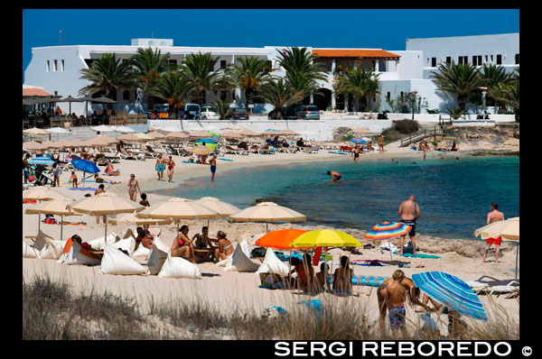 Es Pujols, beach, panoramic view, parasol, deck chair, tourism, holiday. Spain, Balearic Islands, south of Ibiza island, Formentera island, Es Pujols beach. Spain; Formentera; Es Pujols; beach; pujols; background people; balearic; balearic islands; beach; es pujols beach; europe; formentera island; general view; bath; sun; islands; littoral; mediterranean sea; parasol; people; sea; south; spain; tourism; tourist; vacations; island; balearic; Baleares; background; balearic; beach; beautiful; blue; calm; coast; europe; exotic; formentera; holiday; idyllic; island; islet; landmark; landscape; llevant; mediterranean; nature; ocean; outdoor; paradise; places; reflection; sand; scenic; sea; seascape; shallow; shore; sky; spain; summer; sunlight; sunny; tanga; tourism; touristic; transparent; travel; tropic; tropical; turquoise; vacation; water; waves; wavy; wet; white; atrraction; destination; Europe; European; holiday; travel; islands; mediterranean; photos; place; spanish; sun; tourism; touristic; vacation; view; Balearics; beautiful; beauty; paradise; fun; happy; coastal; paradisiac; popular