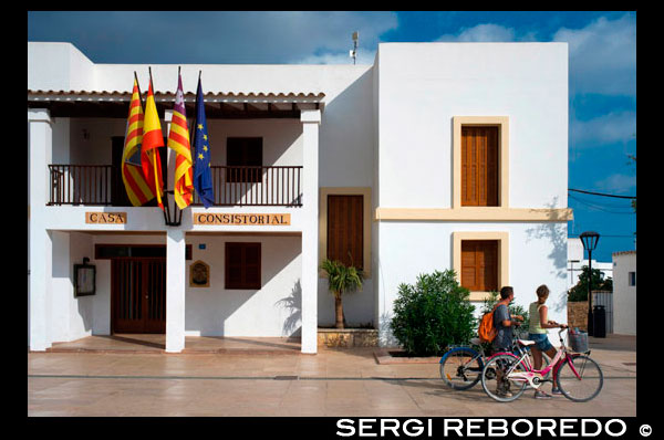 Tourists, Town hall in main square of Sant Francesc Xavier, San Francisco Javier, Formentera, Pityuses, Balearic Islands, Spain, Europe.   Spain; Formentera; island; balearic; Sant Francesc; Xavier; San Francisco; Francisco; Javier; main; square; bicycle; bike; central; typical; white; houses; house; tourists; nice; town hall; day; daylight; daytime; during; europe; european; exterior; exteriors; formentera; holiday; holidays; island; islands; javier; journey; outdoor; photo; photos; pityuses; place; places; san; sant; shot; shots; small; south; southern; spain; spanish; square; squares; tourism; tourists; town; towns; travel; travelling; travels; trip; trips; vacation; vacations; village; villages; Baleares; atrraction; destination; Europe; European; holiday; travel; islands; mediterranean; photos; place; spanish; sun; tourism; touristic; vacation; view; Balearics; beautiful; beauty; paradise; fun; happy; coastal; paradisiac; popular