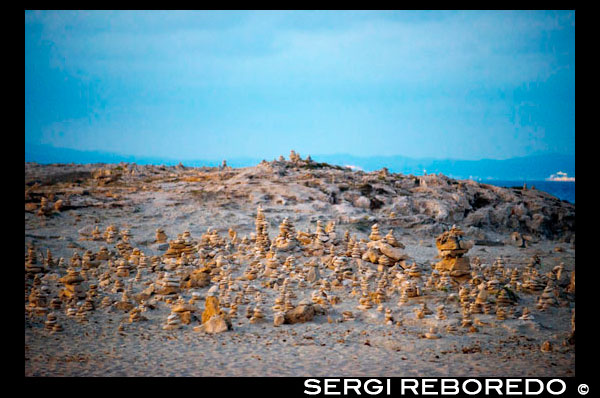 Ses Illetes Beach, Balearic Islands, Formentera, Spain. Backlights in the sunset with stones with different shapes. "The Flood" ("La Riada"), a unique space built with stones by the German Johannes Schultz. Spain; Formentera; island; Ses Illetes; beach; es pas; pas; illetes; sunset; stones; stone; backlight; zen; balance; creative; art; artist; relax; shape; shapes; coastline; marine; scene; outdors; sand; summer; balearic; nice; sea; boats; pretty; sunset; couple; walk; walking; sand; beauty; calo; beach; beautiful; beauty; blue; coast; people; man; woman; romantic; europe; holiday; idyllic; isla; island; islands; islet; landmark; landscape; mediterranean; nature; ocean; outdoor; paradise; places; rock; rocky; san; scenic; sea; seascape; shallow; shore; sky; spain; stones; holiday; horizon; islands; length; look; med; mediterranean europe; platge; platja; playa; rear; rocks; rocky; rough; sand; sandy; sea; single; slim; spain; spanish; stand; summer; tourism; travel; vacation; view; watch; wave; sun; sunny; touristic; transparent; travel; turquoise; vacation; water; waves; white; balearic; Baleares; atrraction; destination; Europe; European; holiday; travel; islands; mediterranean; photos; place; spanish; sun; tourism; touristic; vacation; view; Balearics; beautiful; beauty; paradise; fun; happy; coastal; paradisiac; popular