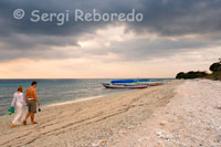 Una parella passeja per la sorra de la platja de la zona Oest de l'illa, prop de l'embarcador del Bounty Resort. Gili Meno.