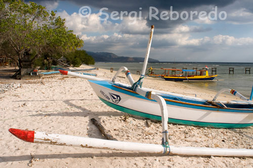 Unes barques descansen a la sorra de la platja de la zona Oest de l'illa, prop de l'embarcador del Bounty Resort. Gili Meno. No hi ha cotxes ni motos a tota l'illa i l'única possibilitat de transport que no comporta la utilització dels teus peus, són els carros tirats per cavalls anomenats "cidomos".