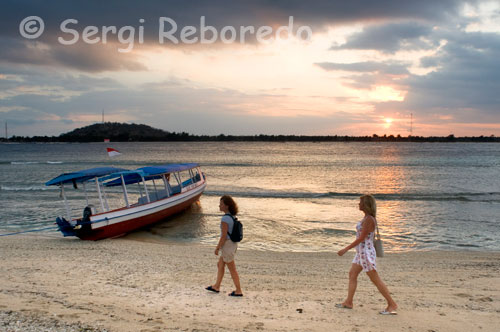 Dos mujeres pasean por la arena de la playa de la zona Oeste de la isla, cerca del embarcadero del Bounty Resort. Gili Meno. MENO SLOPE  Una inmersión de corriente a lo largo de la bajada de Meno es por lo general una experiencia agradable. Usted descenderá por el canal entre Gili Trawangan y Gili Meno y descenderá al fondo del arrecife a 22m. La profundidad media para el resto de la inmersión será de 16m, con lo cual este punto es perfecto para todos los niveles de certificación. Hacia el final de este punto de inmersión usted se encontrará explorando el pecio Bounty Pontoon. Este barco hundido es una estructura intacta de 12 metros llena de interesante vida marina, algunos cardúmenes de peces de arrecife. En los alrededores del pecio se pueden encontrar peces león, peces escorpión, variedad de nudibranquios y algunas tortugas. A lo largo del descenso del arrecife usted encontrará una serie de corales duros y suaves con una buena cantidad peces que le mantendrán entretenido. Es común ver rayas Águila, Tortugas, Meros, peces ballesta, morenas, serpientes de mar, tiburones puntas blancas de arrecife.
