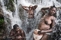 Tres amigas se purifican el alma en el agua que mana de la cascada de Saut d'Eau. Para ellas este baño puede representar tanto la purificación como el hecho de que algunos de sus deseos se puedan convertir en realidad. La palabra Vodou procede de Benín y significa fon vodu (espiritu divino). Varias mujeres se bañan para purificarse y pedir favores a los espíritus. Aunque proviene de África, el vudú no es una religión animista en la que se rende culto a los espíritus, sino que los devotos creen en un solo dios, el Gran Met (Gran Maestro), al que adoran. Como en Gran Met está en un plano muy alejado del físico, para poder contactar con el en una ceremonia es preciso hacerlo a través de unas entidades menores llamadas Iwa que sirven como interlocutores entre Dios y los hombres.