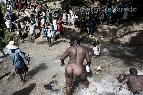 Una vez van llegando al riachuelo que forma la cascada la gente se despoja de su ropa vieja. Los cuerpos, los cantos y la música "rará", común en las celebraciones vudúes, se mezclan con perfumes de hierbas y pociones preparadas para pedir favores a los espíritus. Los creyentes pasan horas bajo en el agua, rezan, extienden los brazos al cielo, se abrazan. Muchos lanzan al cielo su ropa vieja, símbolo de un pasado que quieren dejar atrás, y traen consigo hierbas medicinales. Algunos consultan a los "hougan" (sacerdotes) o a las "mambó" (sacerdotisas) que estarían poseídos por algunos de los loas, divinidades del Vudú.